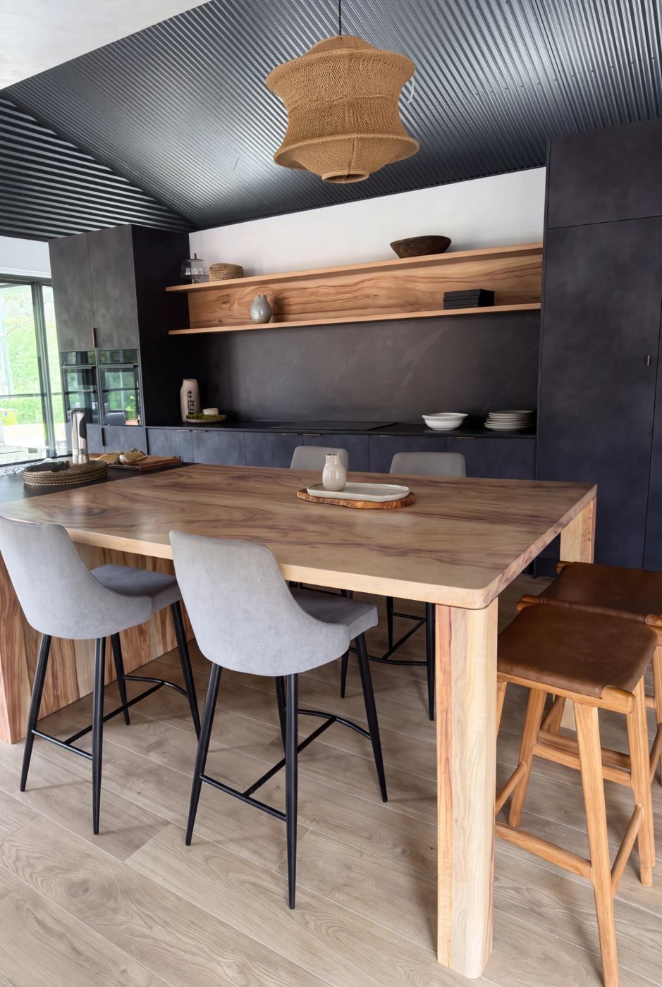 Timber island bench with thick timber legs and floating timber shelves in a charcoal kitchen