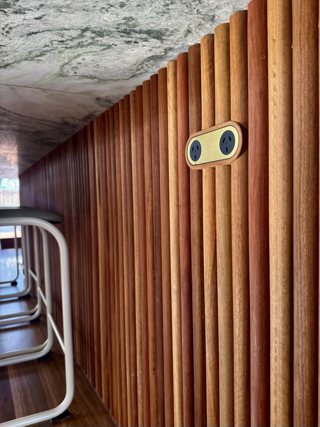 Power point set into a timber surround among the dowels of a kitchen island