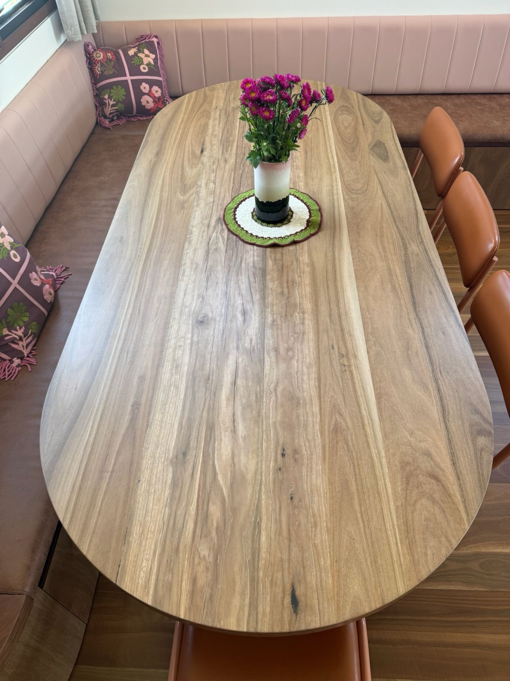 Top-down view of an oval timber tabletop showing the grain